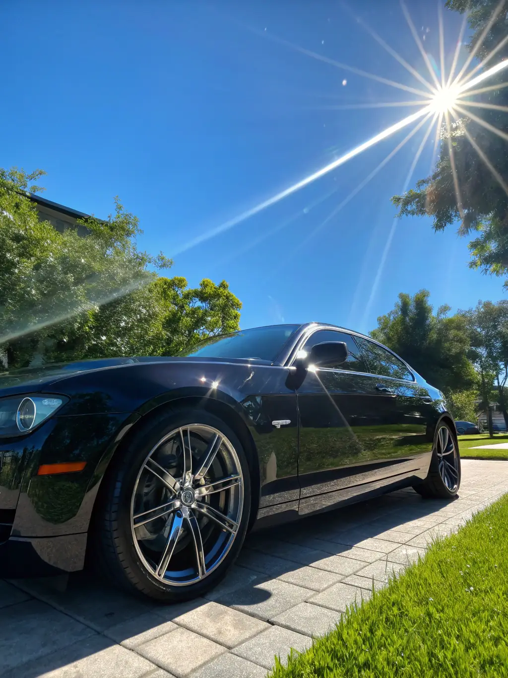 A high-quality image of a car with a gleaming, freshly detailed exterior, water beading perfectly on the surface, taken in bright sunlight to emphasize the shine. This image represents JK Car Detailing's Full Exterior Detailing service.
